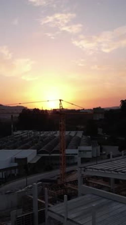 Vertical Video of Crane in building construction at sunset