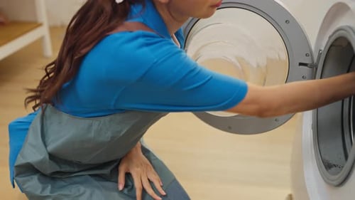 Close up Asian housekeeper or housemaid action of smelly from cloth before put it to washing machin