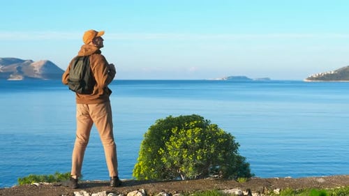 Traveler Admiring Seascape View on Cliff Top