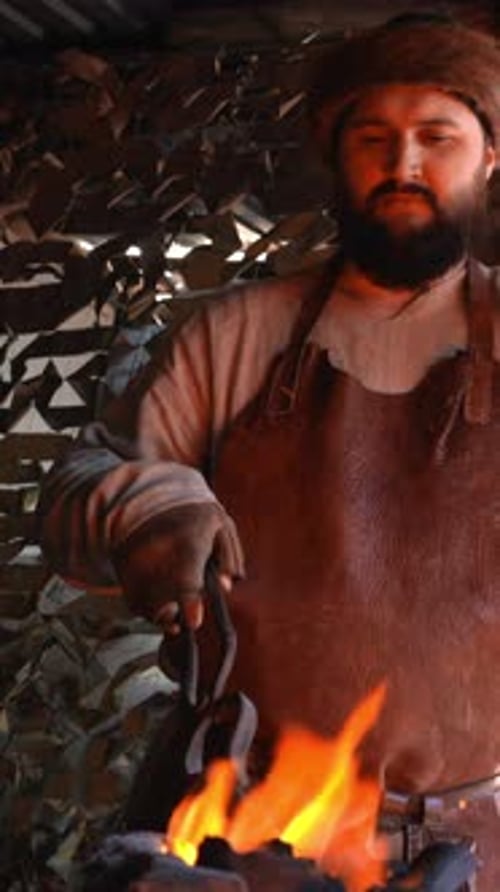A Working Blacksmith Media An Adult Man Who Works with Iron and Fire with Wooden Equipment