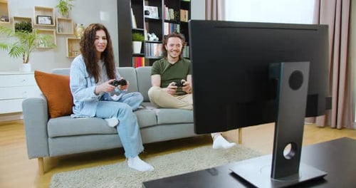 Couple Playing Video Games Together on Couch at Home