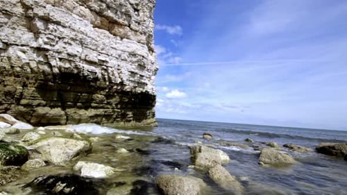 waves lapping over rocks next to the cliffs in north landing bridlington