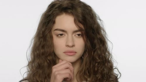 Thoughtful woman has a brilliant idea, smiles brightly