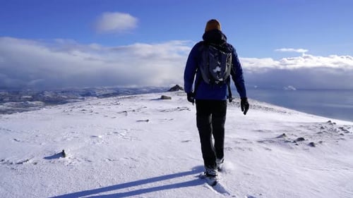 Male hiker walking through the snow on the summit of the Cuillin Mountains in Scotland