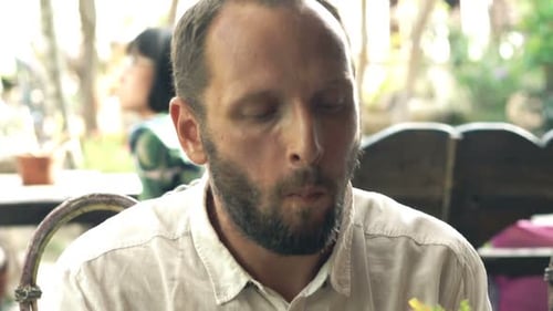 Young man enjoys tasty lunch and fresh sandwich at an outdoor cafe
