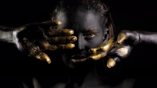 Kunstporträt eines weiblichen Models mit schwarzer Haut, goldenen Lippen, Händen und Augen