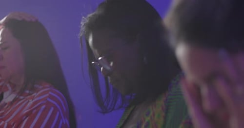 African American woman and Latin woman praying during evangelical church gathering, heads bowed