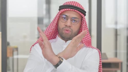 Man in Traditional Dress Gesturing No Indoors
