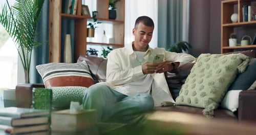 Man Relaxing on Couch Using Smartphone Indoors