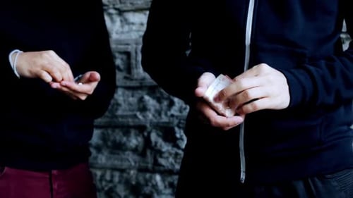 Street drug deal hands exchange cash for pills in illegal trade