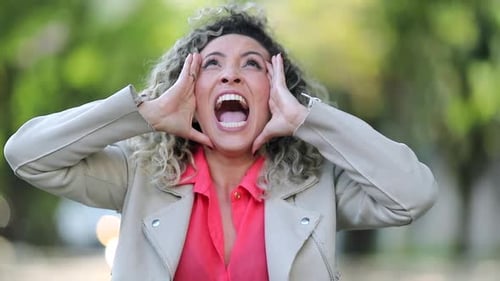 Excited Woman Celebrating Success Outdoors with Curly Hair