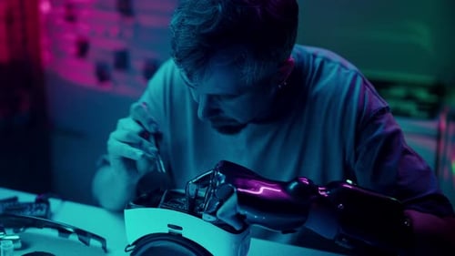 Young Adult Repairing Futuristic Robotic Arm