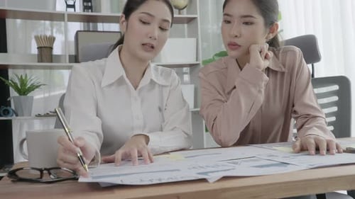Two Young Enthusiastic Businesswoman Working Together in the Office Workspace