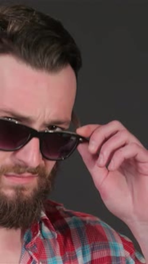 Man Looks over Sunglasses in a Close Up Portrait