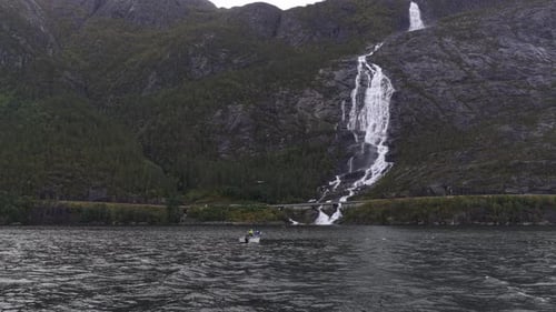High angle shot of Langfossen and fishing boat on calm fjord waters