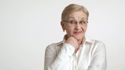 Dissatisfied Old Woman in Glasses White Shirt Standing Over White Background