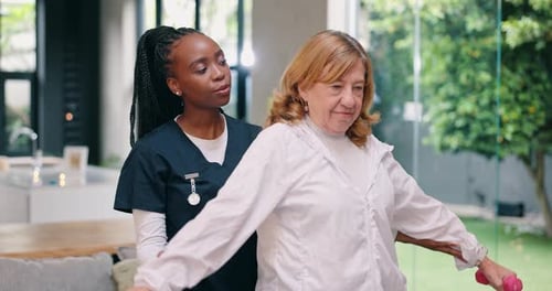 Healthcare Worker Assists Senior Woman With Dumbbell Exercises