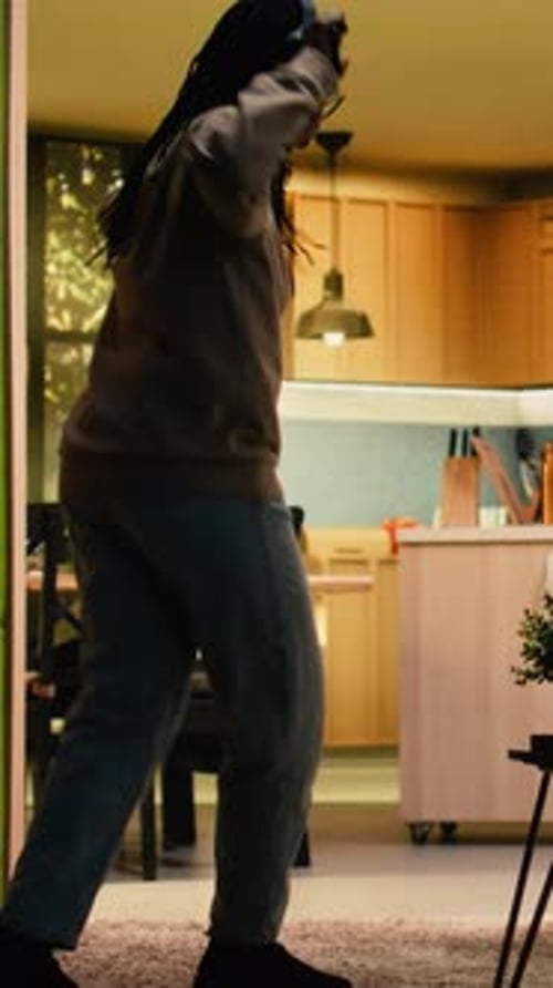 Woman with Headphones Dances in Living Room, Having Fun