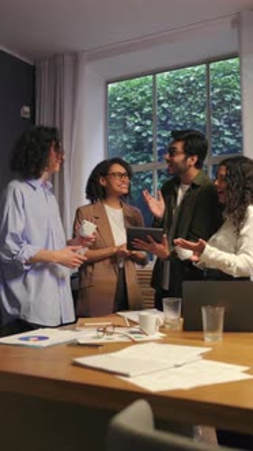 Diverse Business People Laughing and Enjoying Conversation Together During Modern Office Meeting