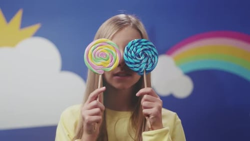 Child Playful Display Playful Young Girl Wearing Vivid Attire Hides Candies and Makes Funny Faces
