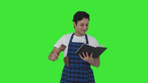 Indian cook making food from recipe book Green screen