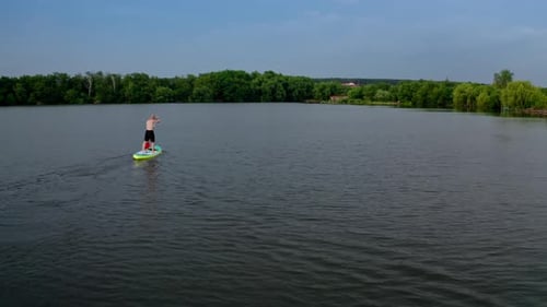 Sup surfer on board. Drone shot of young man stand up paddling on vacation