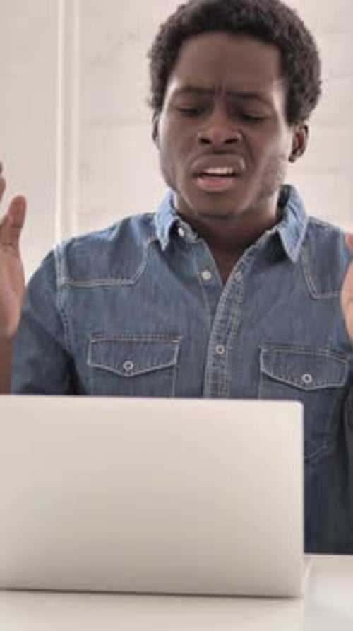 Frustrated Man Using Laptop at Desk Indoors