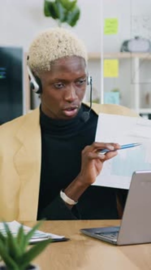 Man Analyzing Charts During Video Conference in Office