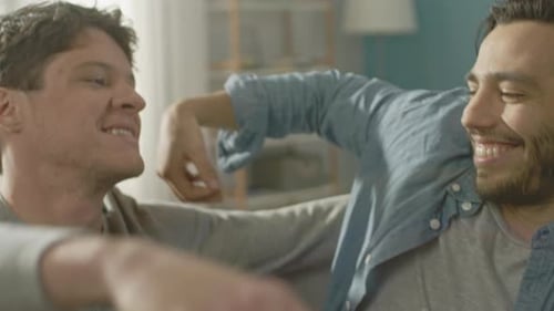 Loving men embrace in cozy home interior