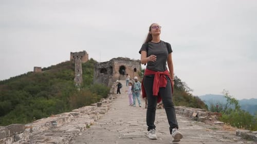 Grupo de mujeres disfrutando de la histórica vista de la ladera con amigos, visitante casual en suéter rojo anudado