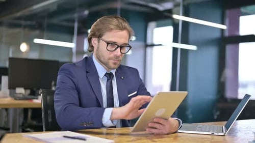 The Businessman Using Tablet in Office
