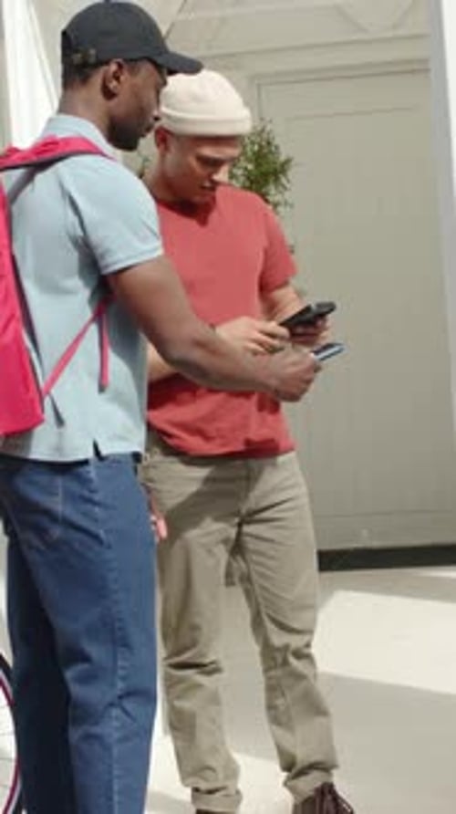 Vídeo vertical: estendendo o dispositivo, o mensageiro e o residente tocando, confirmando a entrega na porta da mochila vermelha