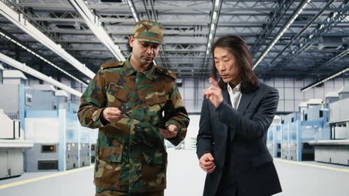 Two Men Discuss Technology in Modern Factory Setting