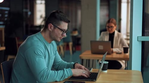 Man Working on Laptop in Modern Office