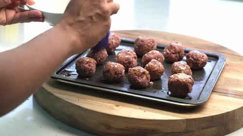 Brushing Sauce on Meatballs Before Baking