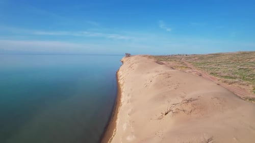 Desert Dune with Blue Sea at Sunrise