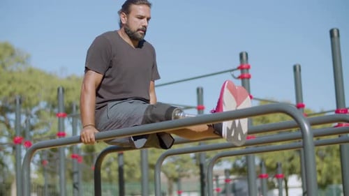 Athlete with Prosthetic Leg Doing Hanging Leg Raises