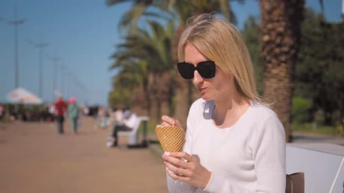 Portrait of beautiful woman eating ice cream on street.