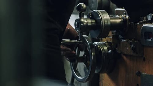 Precision metal lathe operation by skilled machinist in industrial setting