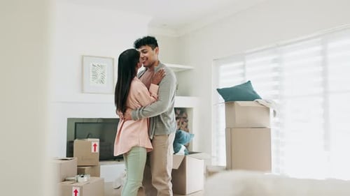 Dancing, couple and kiss to celebrate new home or moving in together with real estate property