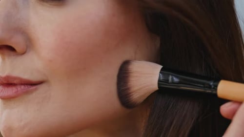 Closeup Lady Applying Foundation Using Cosmetic Brush at Makeup Preparation