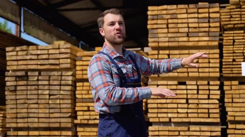 Serious Manager in Uniform Giving Commands to Workers on Lumber Warehouse Bearded Man Gesturing and