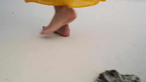 Woman Walking Barefoot On A Beach