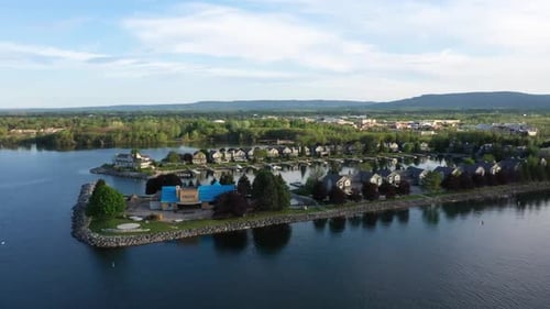 Drone circling over houses built on a lake peninsula in Collingwood.