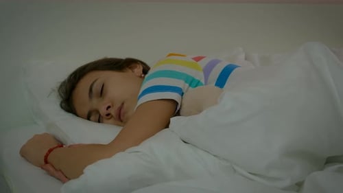 Child Sleeping Soundly in Bed at Home