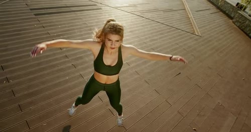 Young Sportswoman Doing Star Jumps on Pier