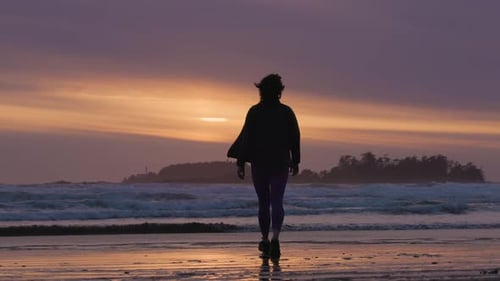Adventurous Woman Standing on the Sandy Beach on the West Coast of Pacific Ocean