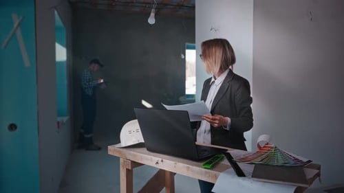 Female Architect Works on Site with Laptop