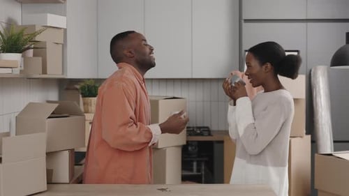 Young Couple Talking in a Kitchen with Moving Boxes