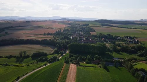 Drone Flight Over Countrysude Area with Small Town and Mountains